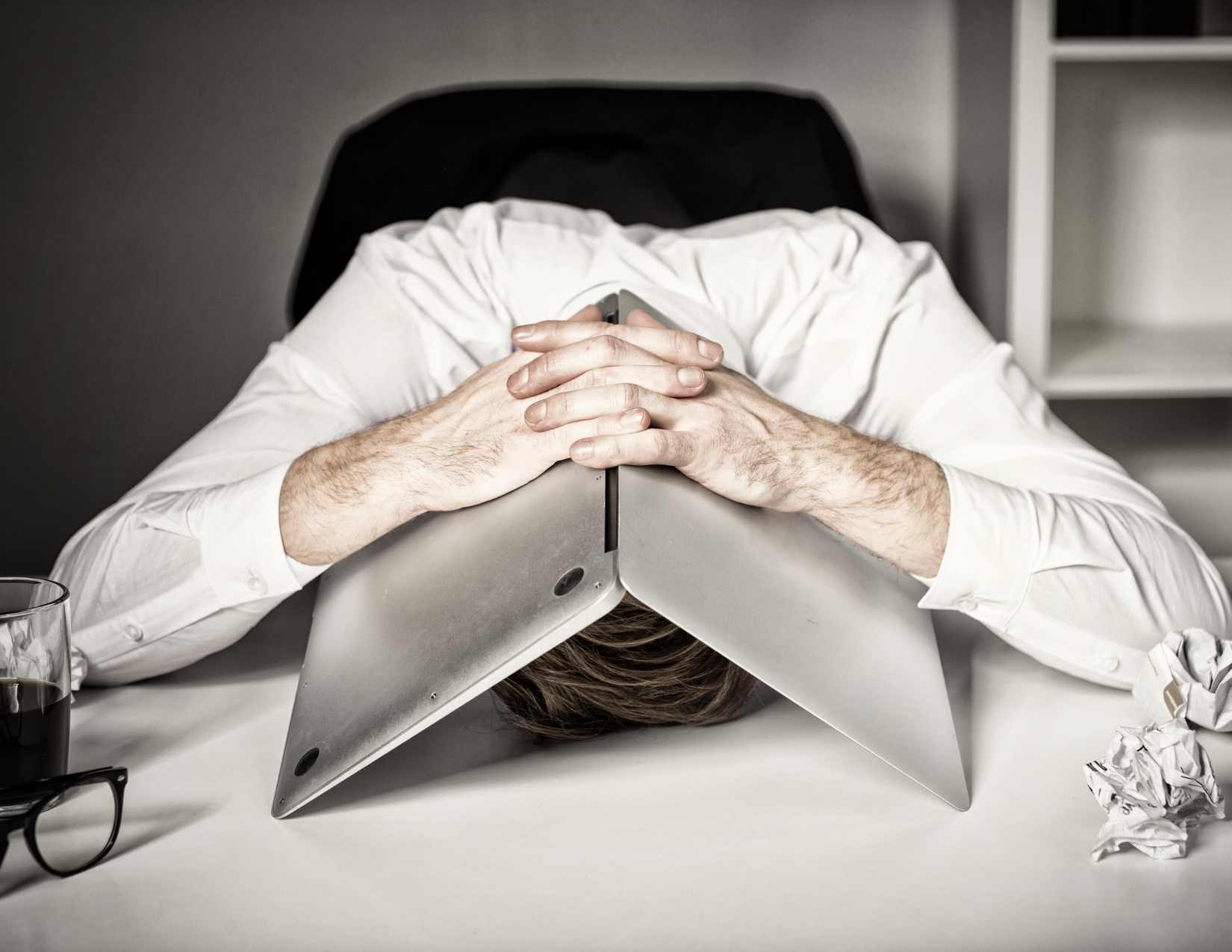 Man with laptop laid over his head