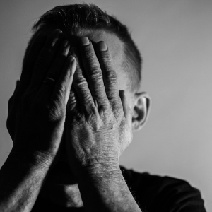 Man holding face with his hands in distress