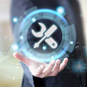 A hand holding a holographic image of a wrench and screwdriver inside a glowing blue circle.